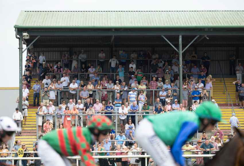 Jockeys flying past the crowded stand at Tramore racecourse