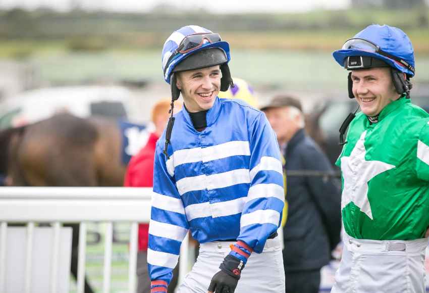 Jockeys laughing together in parade ring