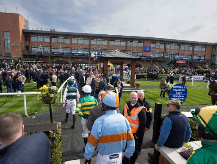 Back image of jockeys entering the parade ring at Fairyhouse racecourse